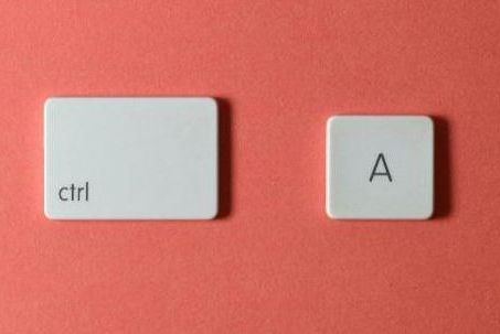 Two white keyboard keys on a pink surface: one larger key labeled ctrl on the left, and a smaller key labeled A on the right.